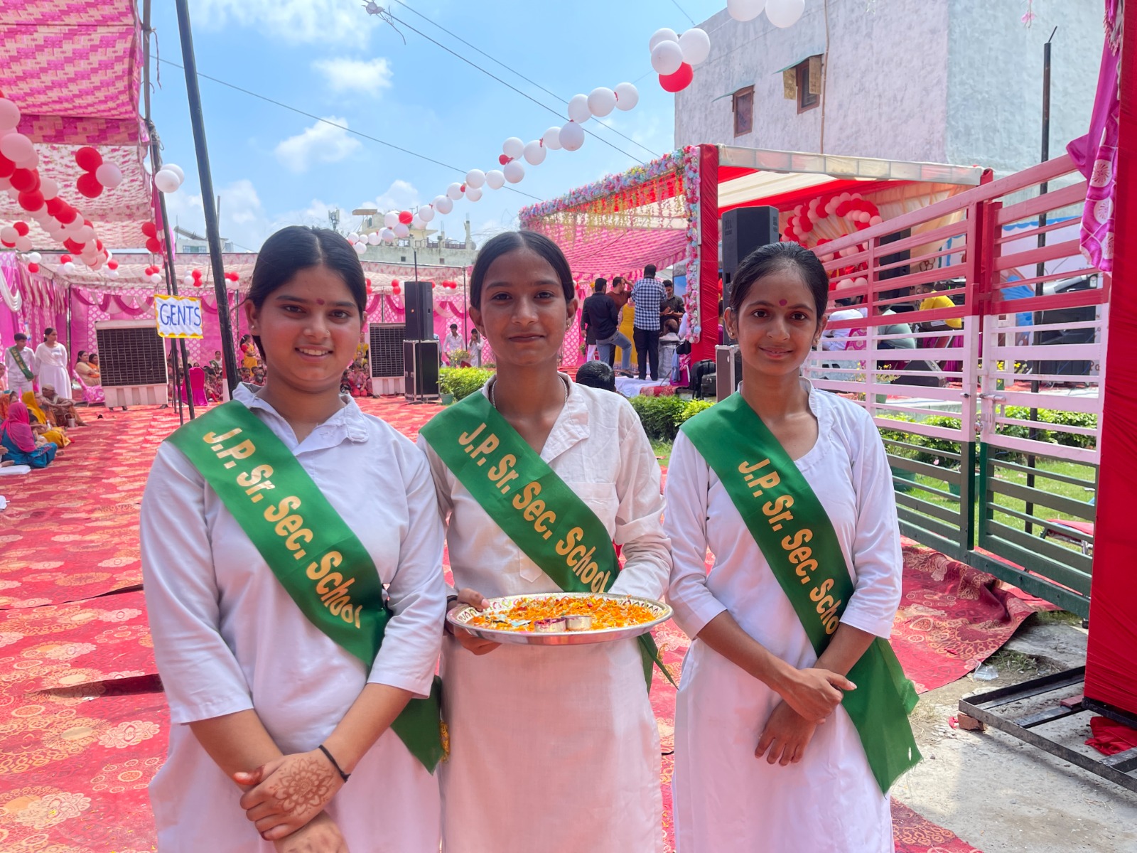J. P. Senior Secondary School students in white kurtas and green sashes at an outdoor annual function